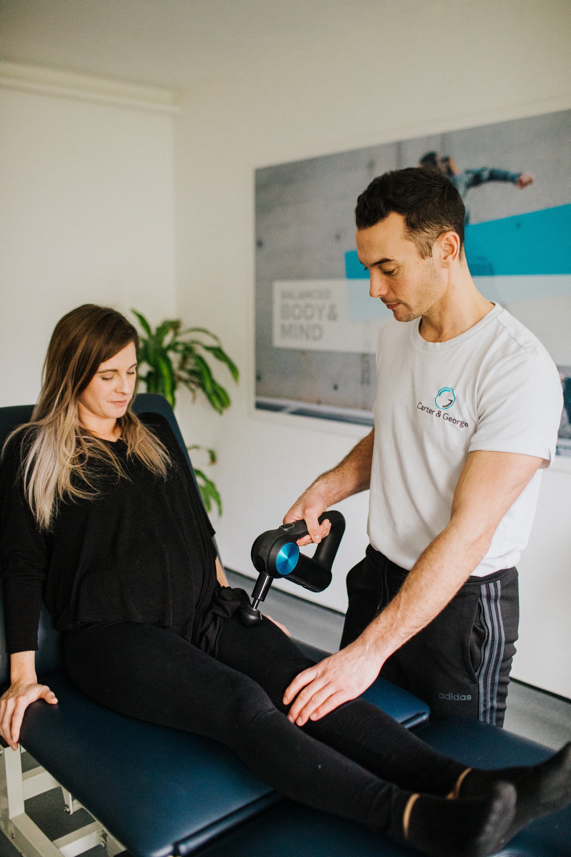 Physiotherapist treating a patient in a modern clinic in Windsor, with professional equipment in use and a calm, supportive atmosphere.